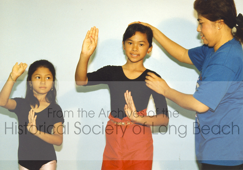 Leng Hang demonstrates the modeling and molding technique used to teach young dancers the proper posture and hand movements required in Cambodian traditional dance.