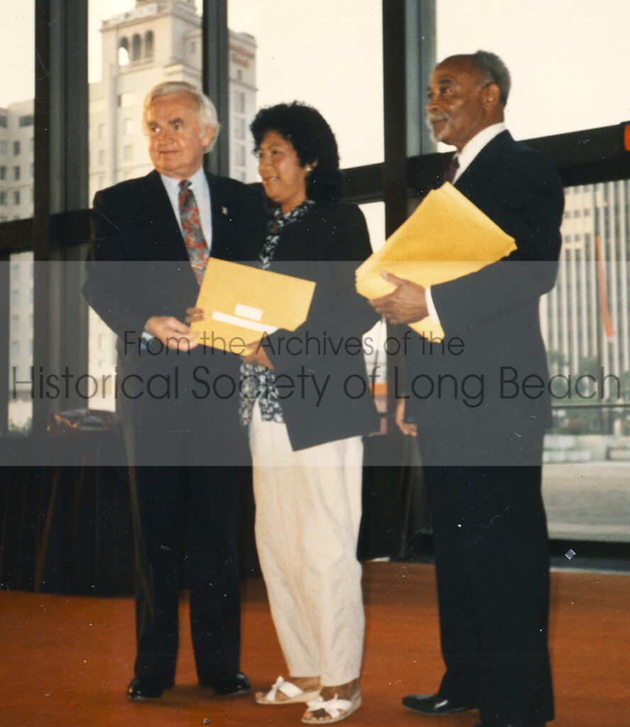 Ernie Kell, mayor of Long Beach (1982-1994), presents Leng Hang (center) an award recognizing her contributions to the City through her Cambodian Arts Preservation Group.