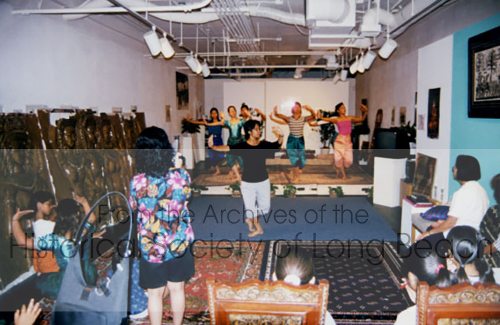 Sophiline Cheam Shapiro teaching dance students in her Long Beach studio, Khmer Arts Academy. Younger students and "dance moms" observe from a distance, some trying to copy the dance movement.