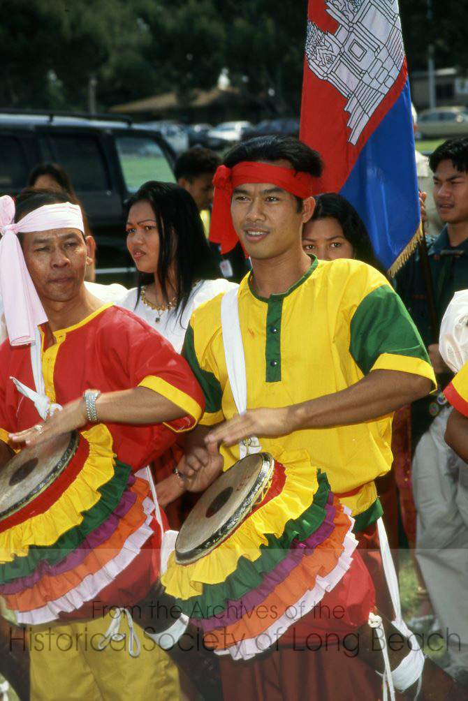 Chhayam dancers play drums as the troupe walks through the crowd at Cambodian New Year celebration at El Dorado Park in Long Beach, California. Audience members are encouraged to join in the dance. (Photo courtesy of Kayte Deioma)
