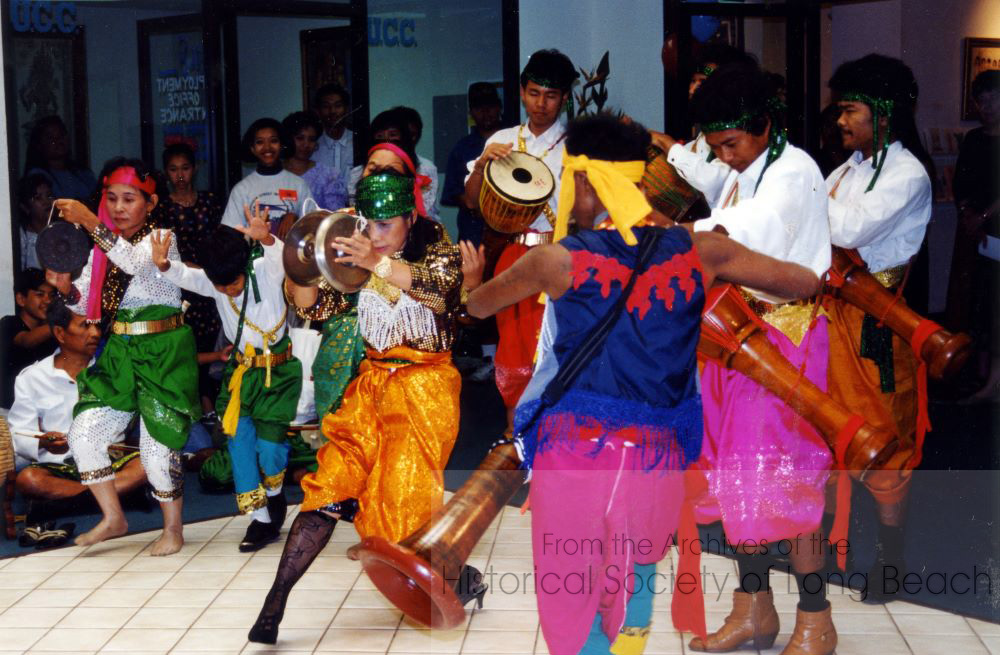 Chhayam is typically performed by a group of dancers, often in a circle or line formation. Dancers wear brightly colored traditional Khmer cloths. Women dancers wear sampot, sarong-style skirts adorned with decorative patterns, while male dancers wear loose-fitting pants and shirts. Both genders may wear ornate jewelry and accessories. (Photo courtesy of Kayte Deioma)