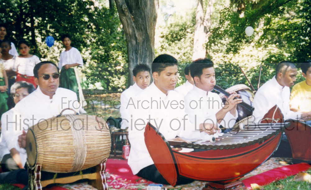 Master musician Ho Chan (far left) plays the drum called Skor while his young male students play the flute and Roneat Ek, Cambodian xylophone, at Cambodian New Year event in the park.
