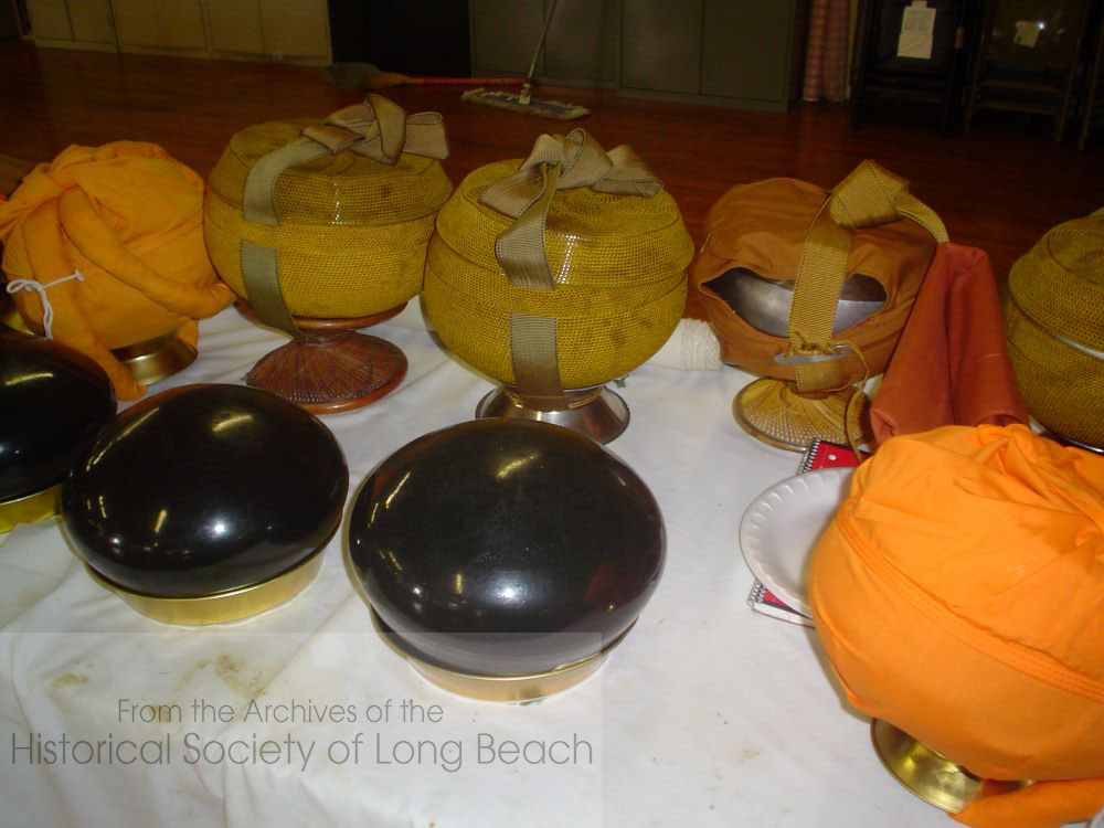 Buddhist monks eat only once a day, and they may not cook for themselves. In Cambodia monks walk through the village each morning with their alms bowls (pictured) into which, villagers will place food. Receiving their food in this way is part of the monk’s discipline in humility while villagers earn merit for their action of giving. This activity is difficult to perform in the U.S., so many temples have made alms giving and receiving a symbolic part of other ceremonies. The monks will stand in a row, while the practitioners file by placing a spoonful of rice in each monks’ alms bowl.