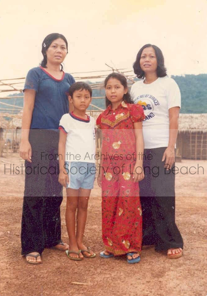 Janet Vanniroth (in red) in front of the orphanage at the Khao-I-Dang refugee center, Thailand, 1980. Janet is with her mother, Vannsath Nguon (in white t-shirt) and a staff friend, Yanine Ray (in blue), with her son. Yanine’s son now lives in Colorado and is an optometrist.