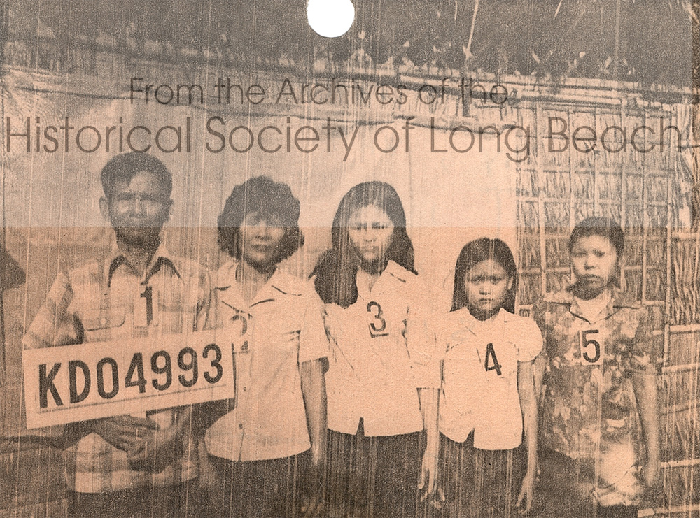 Kam Lou Lopez’s family in a photo documenting that they had been accepted as refugees into the Khao-I-Dang refugee camp, 1981. From left to right: Kam’s father, Man Lou; mother, Fang Phar; Kam; her sister, Meicy; cousin, Seav (cousin’s last name unknown). One of Kam’s uncles sponsored them to the U.S. The family took the uncle’s last name, Sy. When they became U.S. citizens they changed it back to Lou.