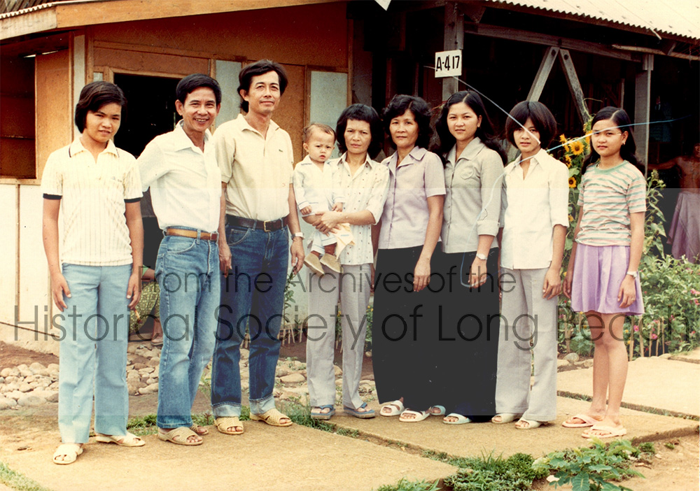 Kam Lou Lopez with family and friends at the processing center in Bataan, Philippines, 1983. Her father, Man Lou, is 2nd from left; her mother, Fang Phar, is 4th from right; and her sister, Meicy Lou, is 2nd from right.