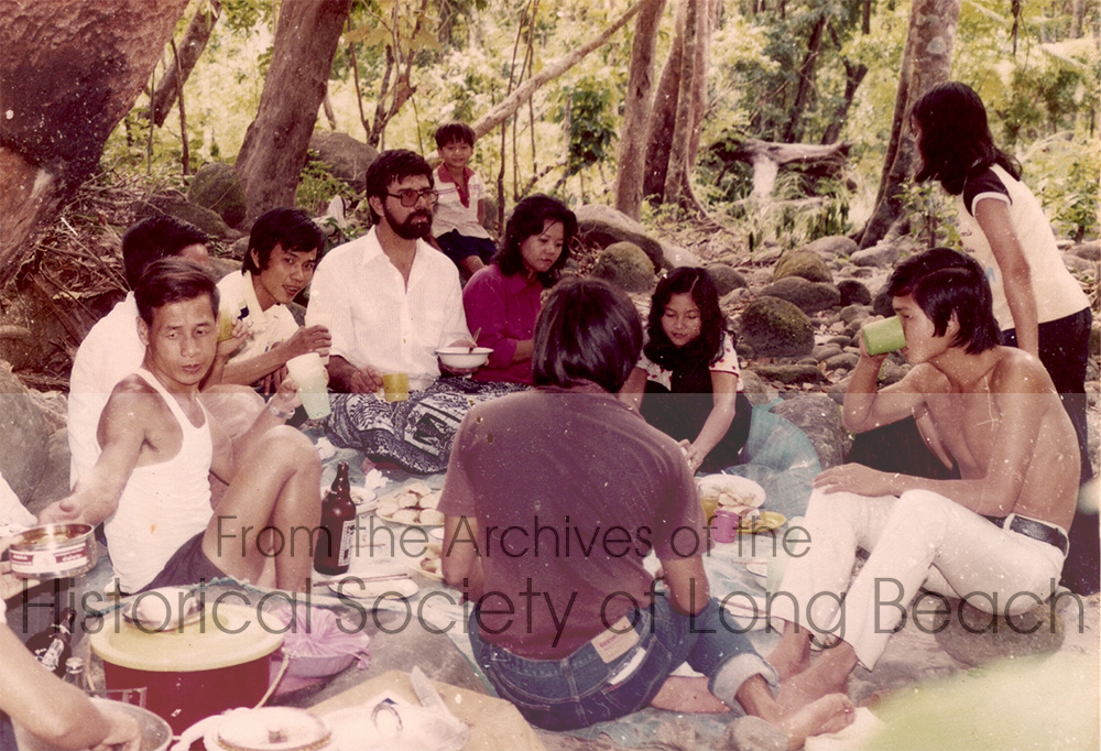A picnic outside the Bataan, Philippines processing camp, 1983. The bearded man was Steven (last name not remembered). He worked for Catholic Charities in the U.S. and was teaching Kam’s brother and sister there. Steven came to visit them in the camp in the Philippines.