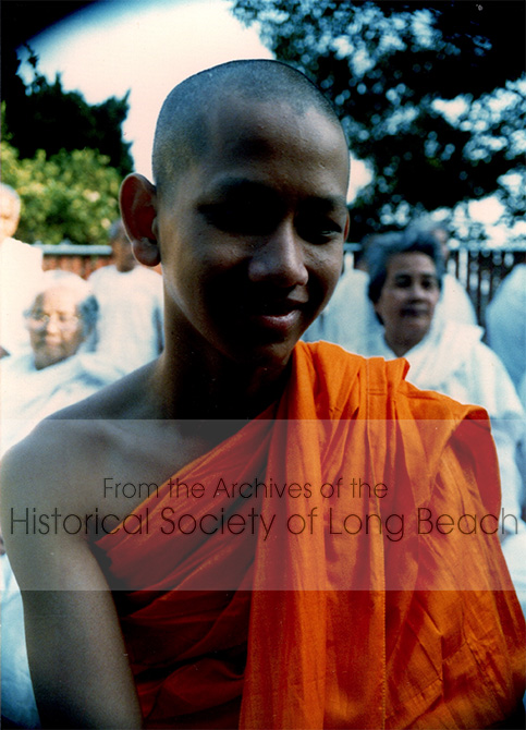 Monorom Neth after his ordination as a novice monk in the first Cambodian Buddhist temple in Lakewood, CA 1985. As a monk he must rise early to chant and meditate, he cannot eat anything after noon, and he may not touch any females, including his mother and sisters. Monorom completed this ceremony to honor his parents. The entire family participated in the ordination ceremony.