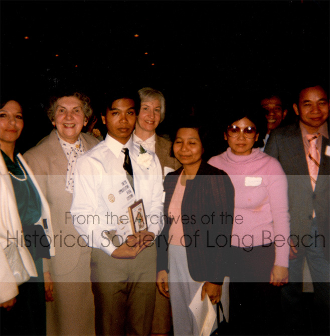 Namoch Sokhom (3rd from left) receiving a certificate from Optimist International in St. Paul, MN, 1984. From left: unnamed; Jeanette Olson who became a close family friend; Namoch; Mrs. Veislav, ESL counselor; Namoch’s mother, Thach In; Cambodia friend that the family stayed with when they arrived in Minnesota, Sam Ol Kahm and her husband, Kim Ean Seng; Namouch’s father, Luy Sokhom, can be seen smiling in the back. Namoch was nominated for the award by his chemistry teacher who was impressed by his positive and trusting outlook, and his hard work.