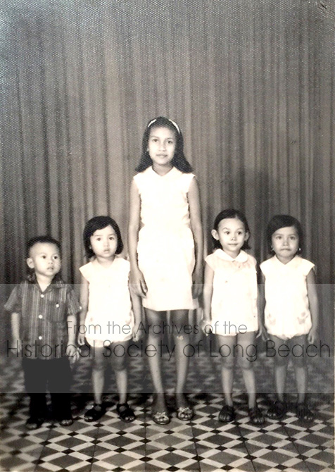 Studio portrait of Sithy Yi and her paternal aunt, Sina Diep, taken in Phnom Penh c. 1974 before the Khmer Rouge took control of Cambodia. The Yi family’s surname prior to the Khmer Rouge was Diep, but the Diep family was marked for execution, so they used Yi instead. From left to right are her cousin, Vithie Diep; her sister, Sithea Yi; her paternal aunt, Sina Diep; her cousin, Vithy Diep; and Sithy Yi.