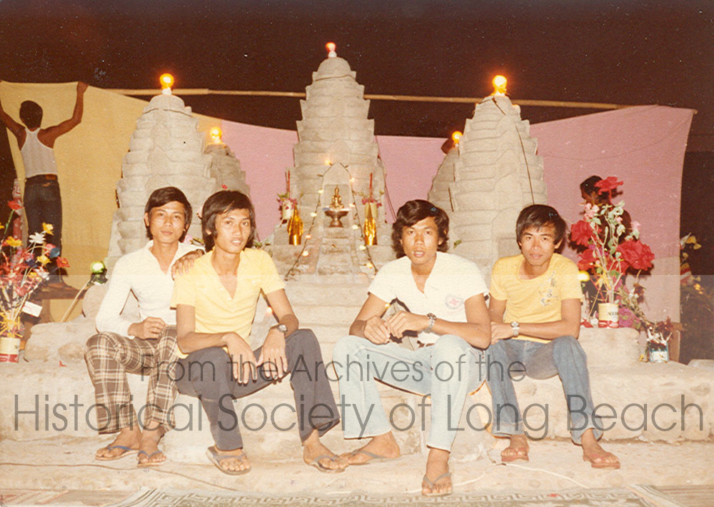 Four young men sitting in front of a replica of Angkor Wat.
